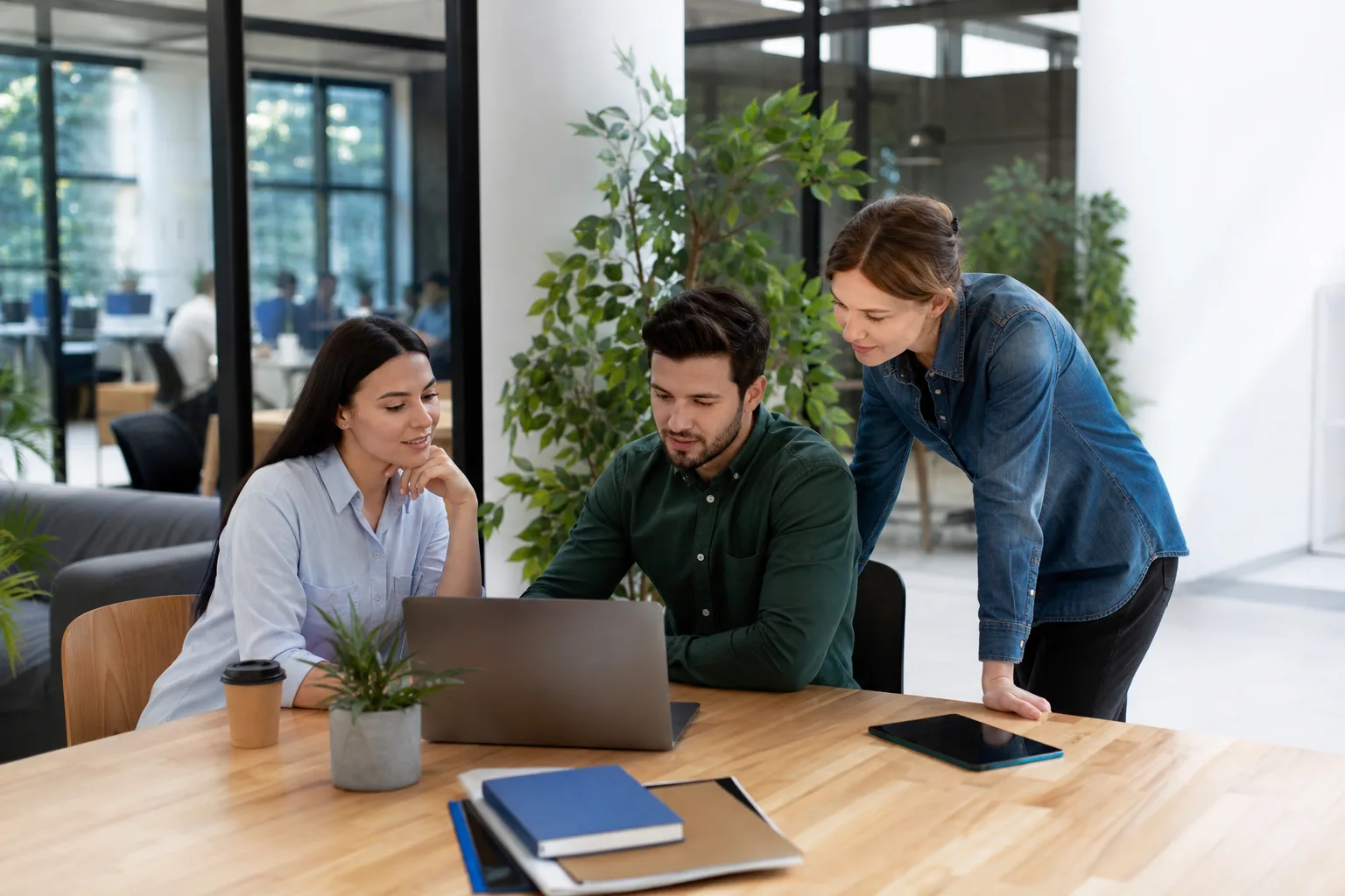 Équipe dans un bureau lumineux consultant le portail web de l'entreprise sur un ordinateur portable